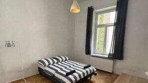 A room with a bed, a table, and a window with curtains. - Fantastic Inn Kraków - Krasińskiego (Kraków)