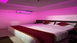 Une chambre à coucher comprenant un lit, une table de chevet et un climatiseur.