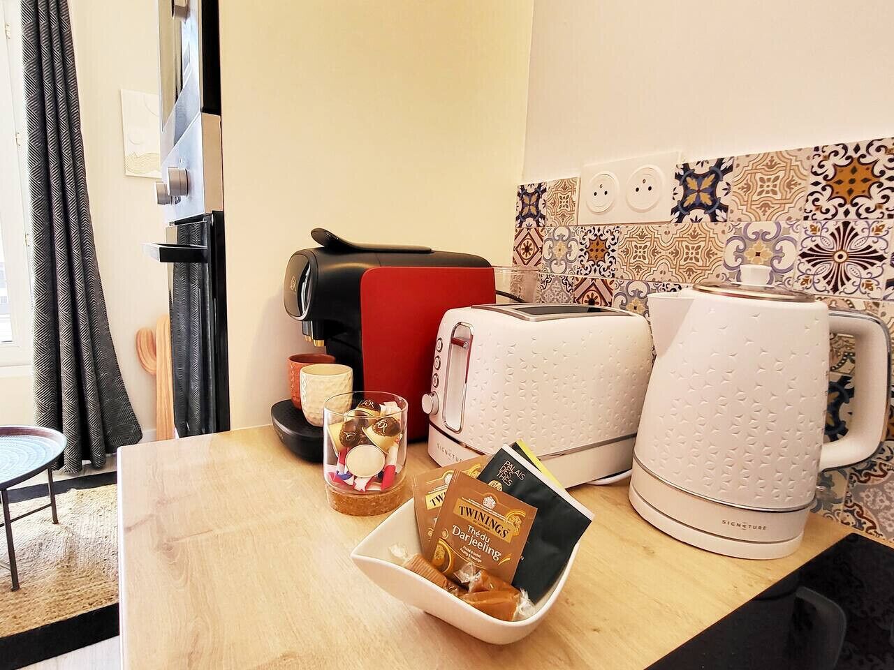 Ein Frühstücksbuffet mit Toaster, Kaffeemaschine und Wasserkocher auf einem Holztisch.