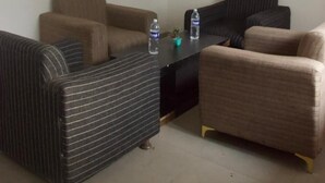 A room with two sofas, a small table with water bottles, and a ceiling with purple and yellow designs. - Hotel Dark Clouds (Sukha)