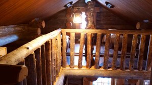 Un escalier en bois avec une rampe menant à une mezzanine.