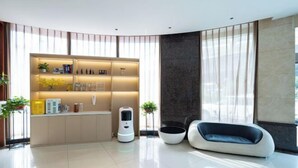 Una sala de estar moderna con cocina integrada, un robot aspirador y una zona de estar original.