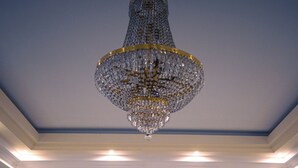 Una hall con un lampadario, una scala e zone relax.