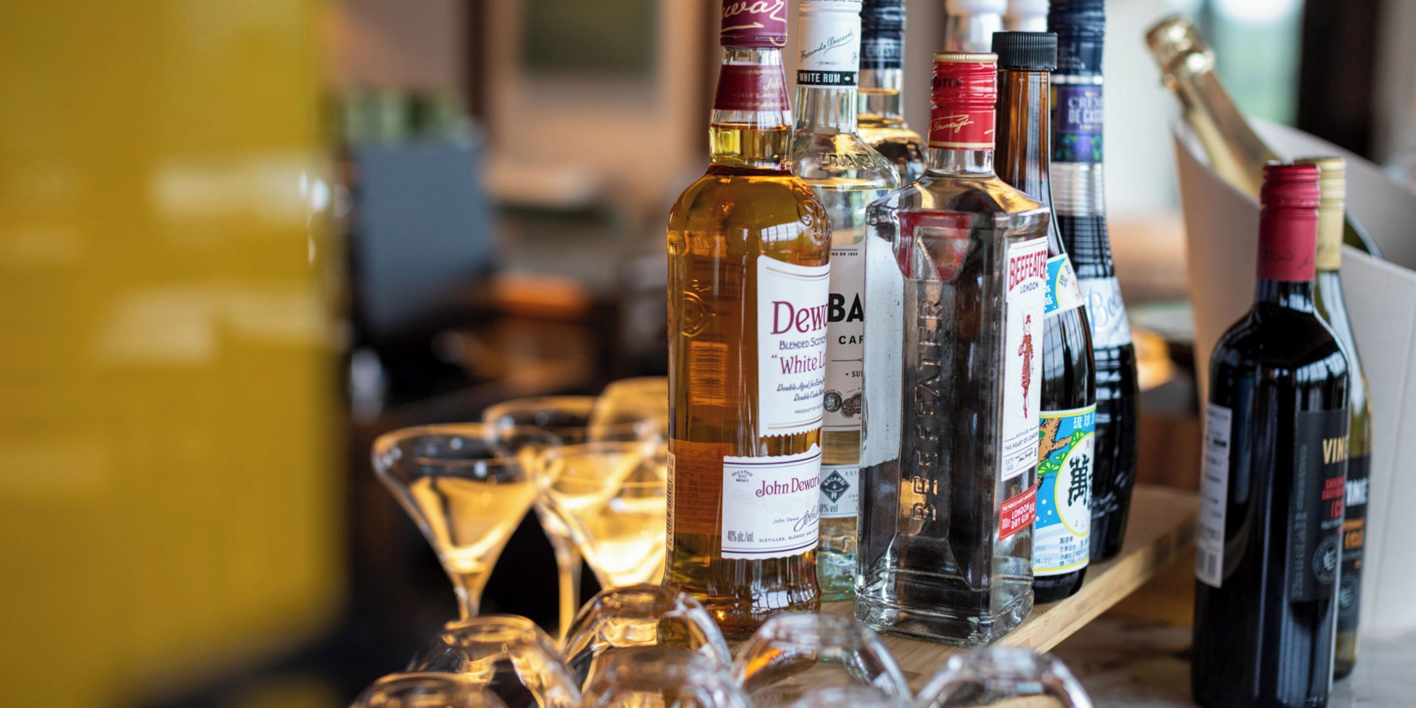 A variety of liquor bottles and glasses on a bar counter.