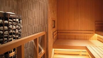 Een houten sauna met banken, een Harvia sauna-oven en een wand met een geometrisch patroon.
