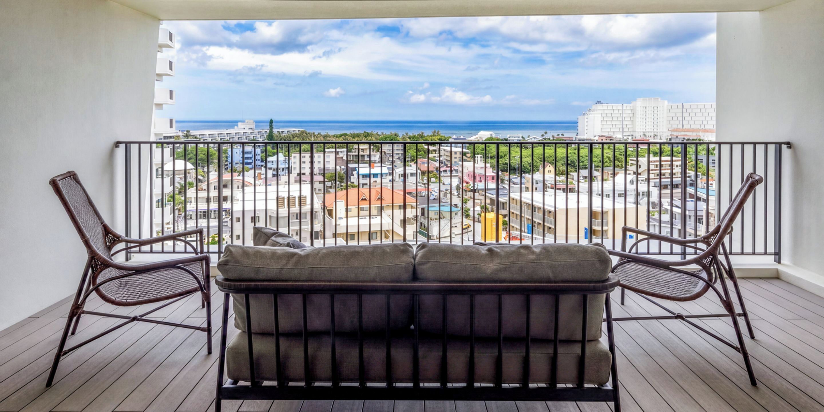 A balcony with a view of a cityscape and the sea.