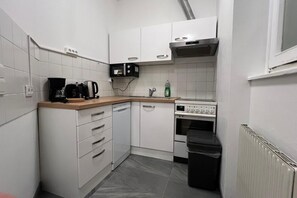 A compact kitchen with white cabinets, a microwave, a coffee maker, a dishwasher, and a stove. - Lovely 3BR Apt. with Balcony near Rennweg station (Vienna)