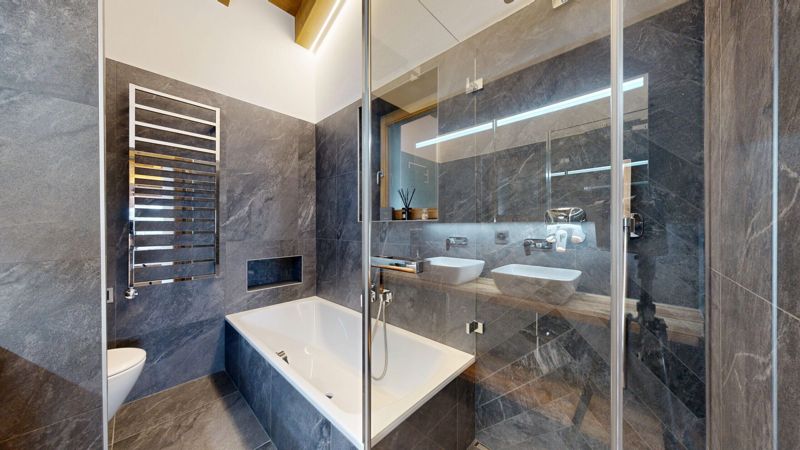Une salle de bain moderne dotée d’une douche à parois de verre, d’une baignoire sur pieds et d’un meuble-lavabo avec un miroir.