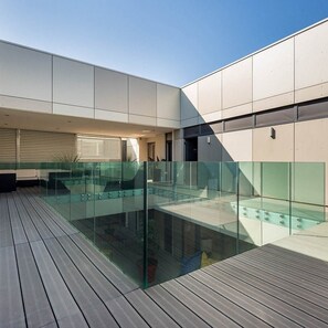 A modern building with a glass-bottomed pool, wooden deck, and a minimalist design. - La Loge de Mer - Urban Lodge - Executive Suite (Perpignan)