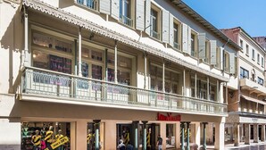 A historic building with a covered walkway and shops on the ground floor. - La Loge de Mer - Urban Lodge - Executive Suite (Perpignan)