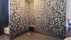 A modern bathroom with a mosaic tile wall, a shower area, and a toilet. - La Loge de Mer - Urban Lodge - Executive Suite (Perpignan)