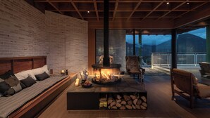A cozy living room with a fireplace, a sofa, and a chair. - LOSTVILLA Deqin Meri Snow Mountain (Deqin)