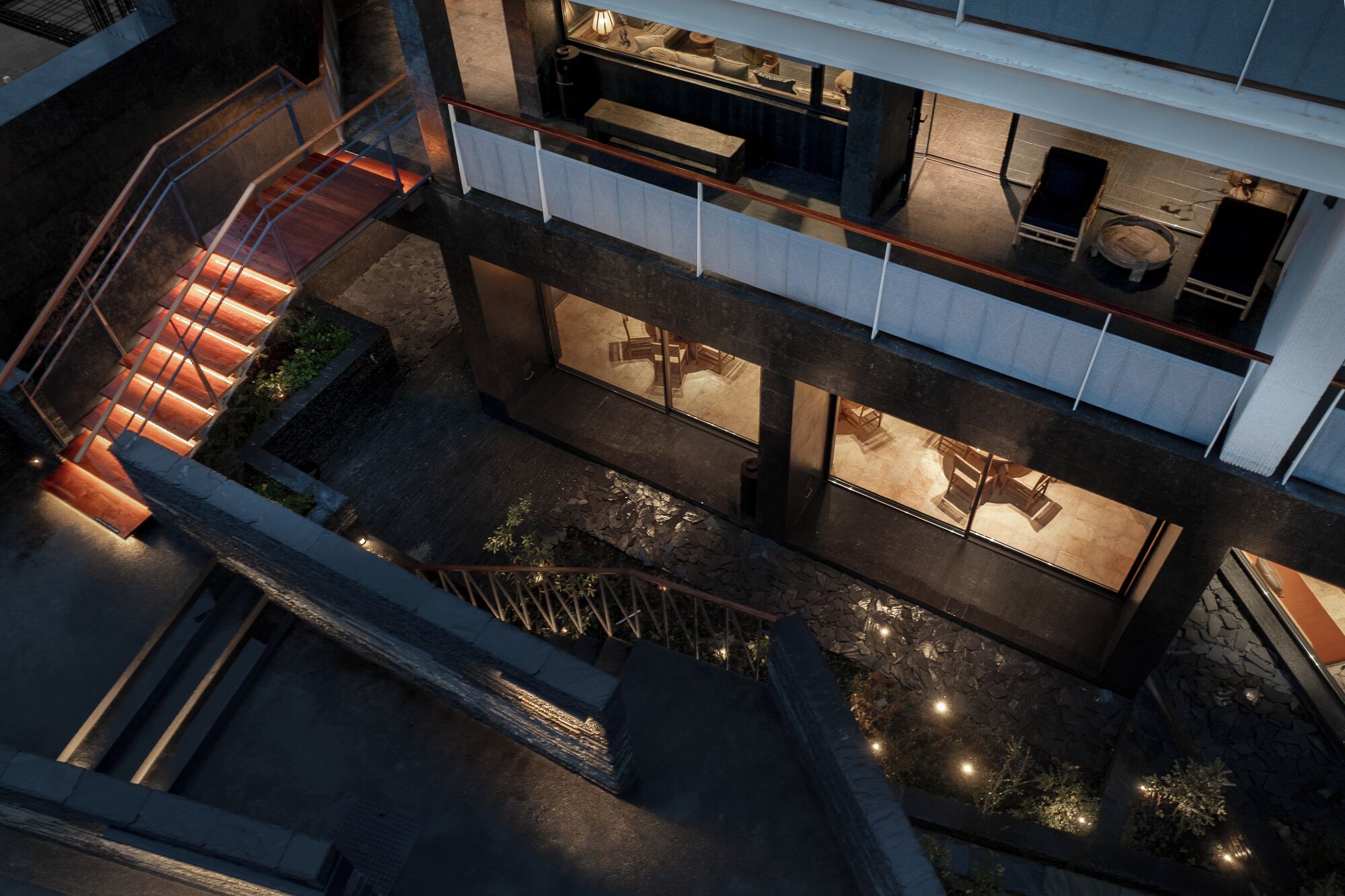 A multi-level building with a staircase, outdoor seating area, and a pool.