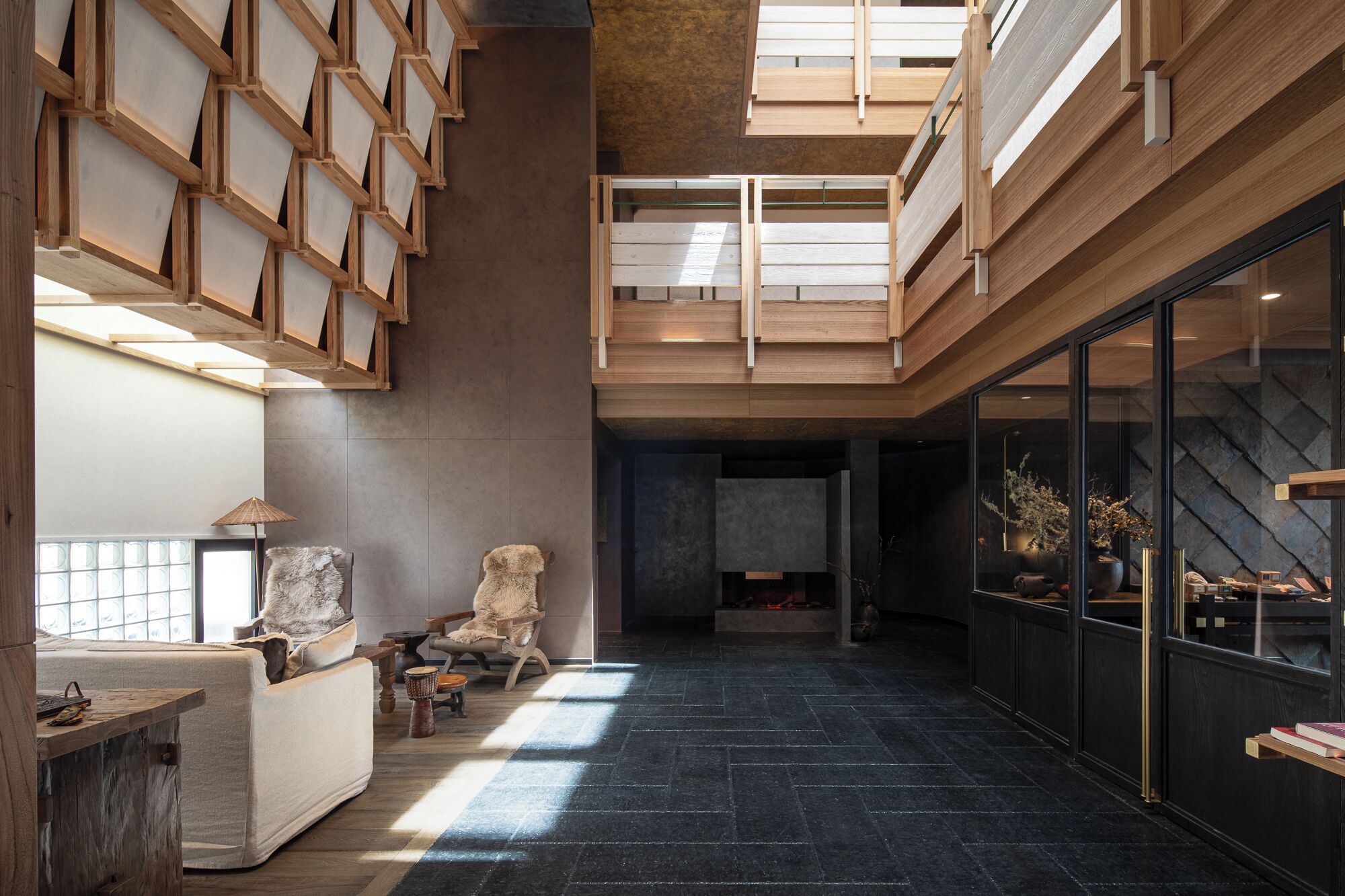 A spacious interior with a high ceiling, a fireplace, and a seating area with a view of the outdoors.