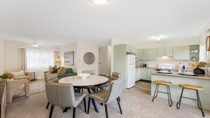 Un appartement moderne comprenant un coin repas, une cuisine et un espace de vie.