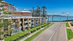 Un hôtel moderne à plusieurs étages, doté de balcons et offrant une vue sur la mer.