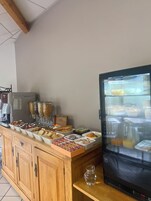 Un área de buffet con diversas opciones de comida y una máquina de café.