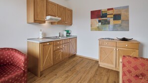 Una cocina compacta con armarios de madera, una encimera y una cafetera.