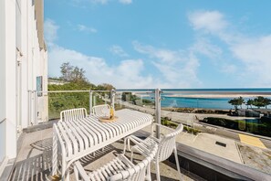 A balcony with a white metal table and chairs, overlooking a beach and ocean. - Gangneung Mutenlol (Gangneung)