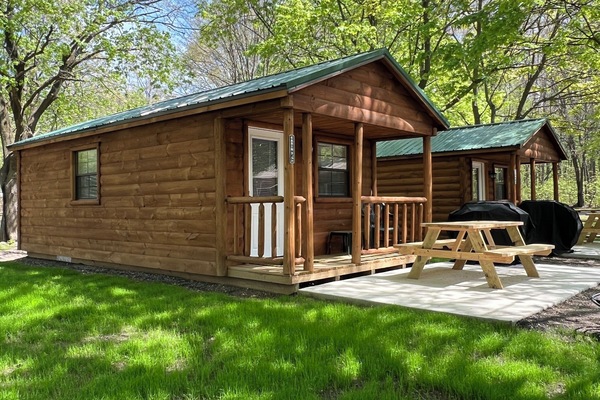 The exterior of Cabin #3 with picnic table, gas grill, and fire-ring.