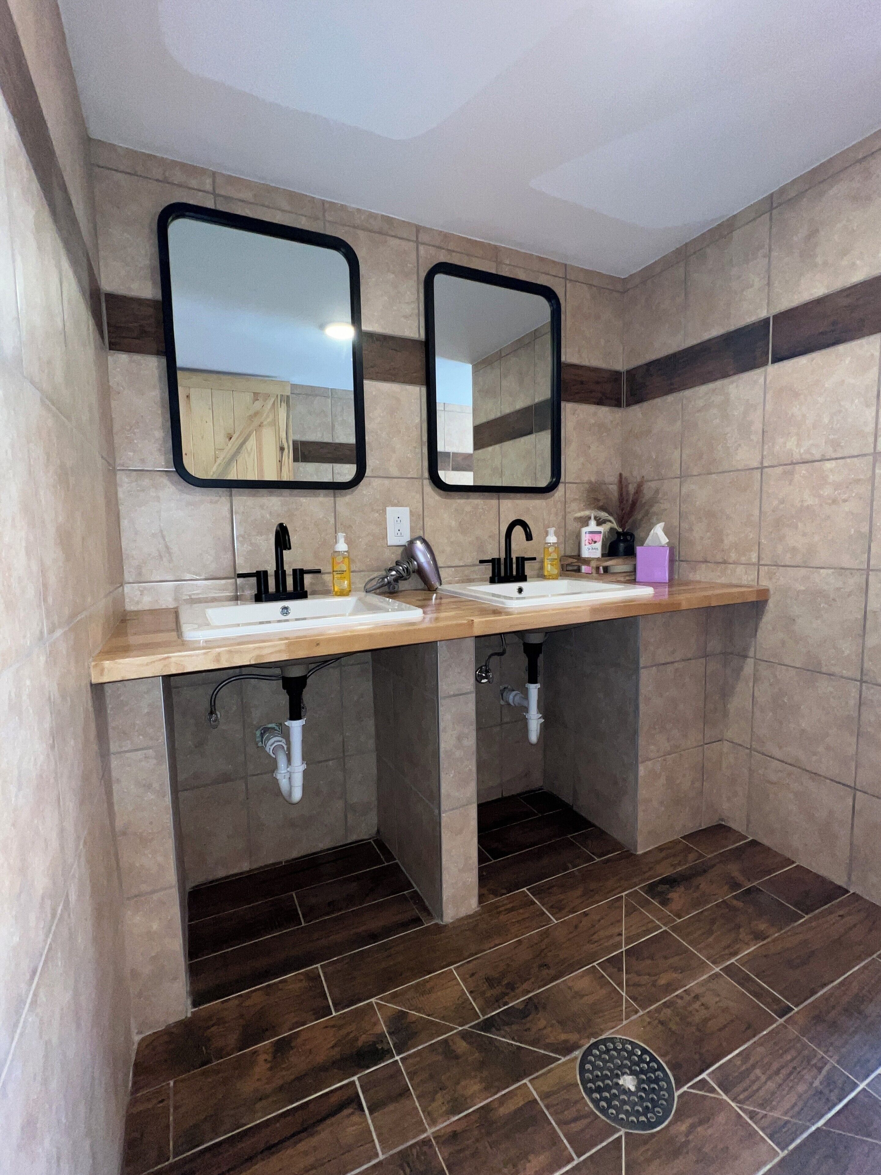A bathroom with two sinks, mirrors, and a vanity.