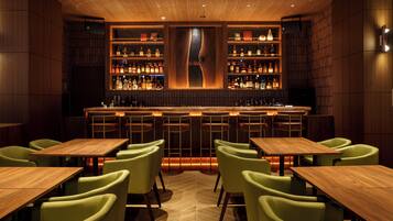 A bar area with wooden furniture and shelves of bottles.