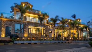 A modern two-story building with a stone facade, large windows, and a balcony. - Dali Sea Coconut Muxin Yeelen Villa (Dali)