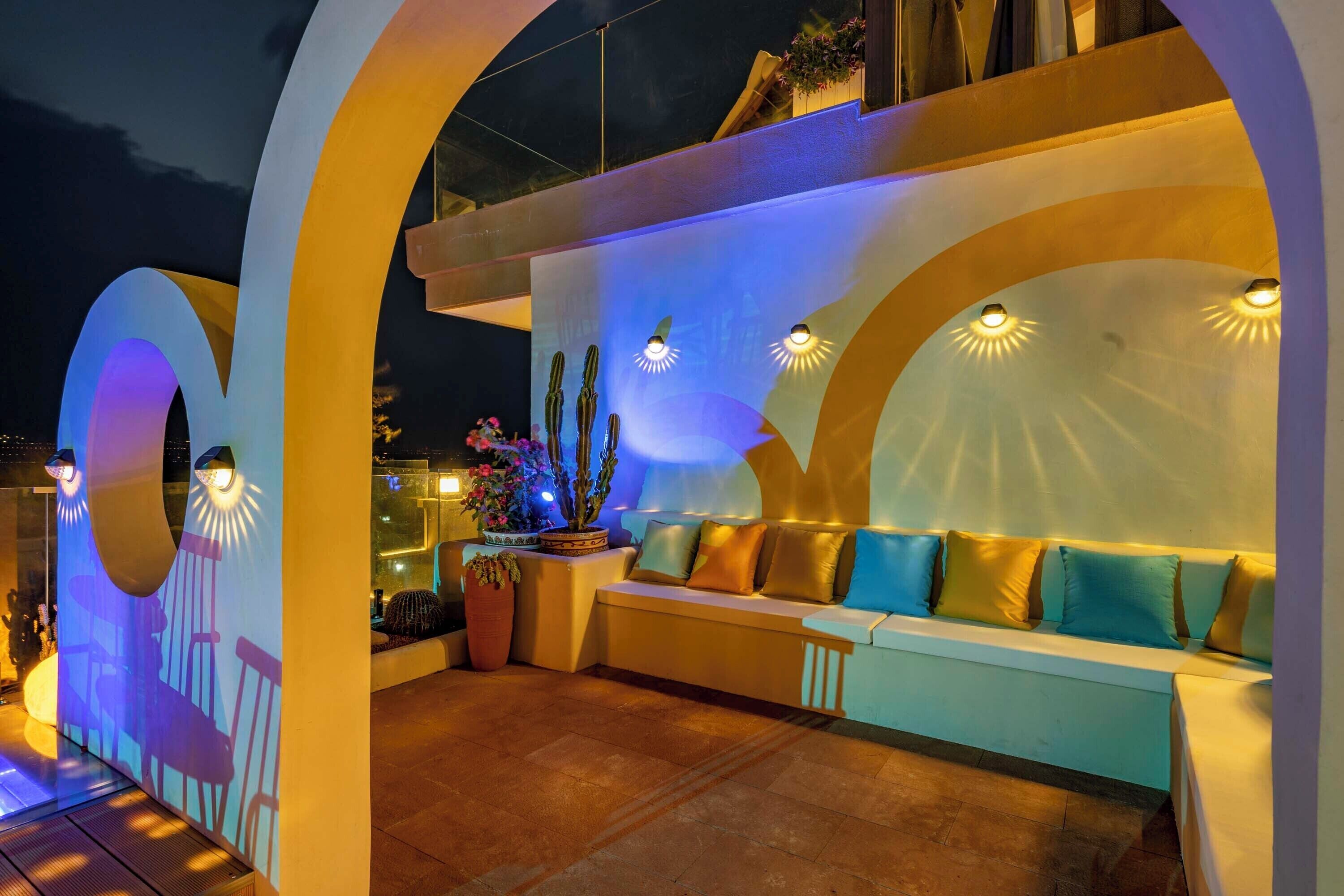 An outdoor seating area with a modern design, featuring a bench and a potted plant.