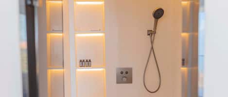 Een moderne badkamer met een douche, verlichte planken en een bedieningspaneel.
