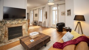 Een woonkamer met een open haard, een bank, een salontafel en een televisie.