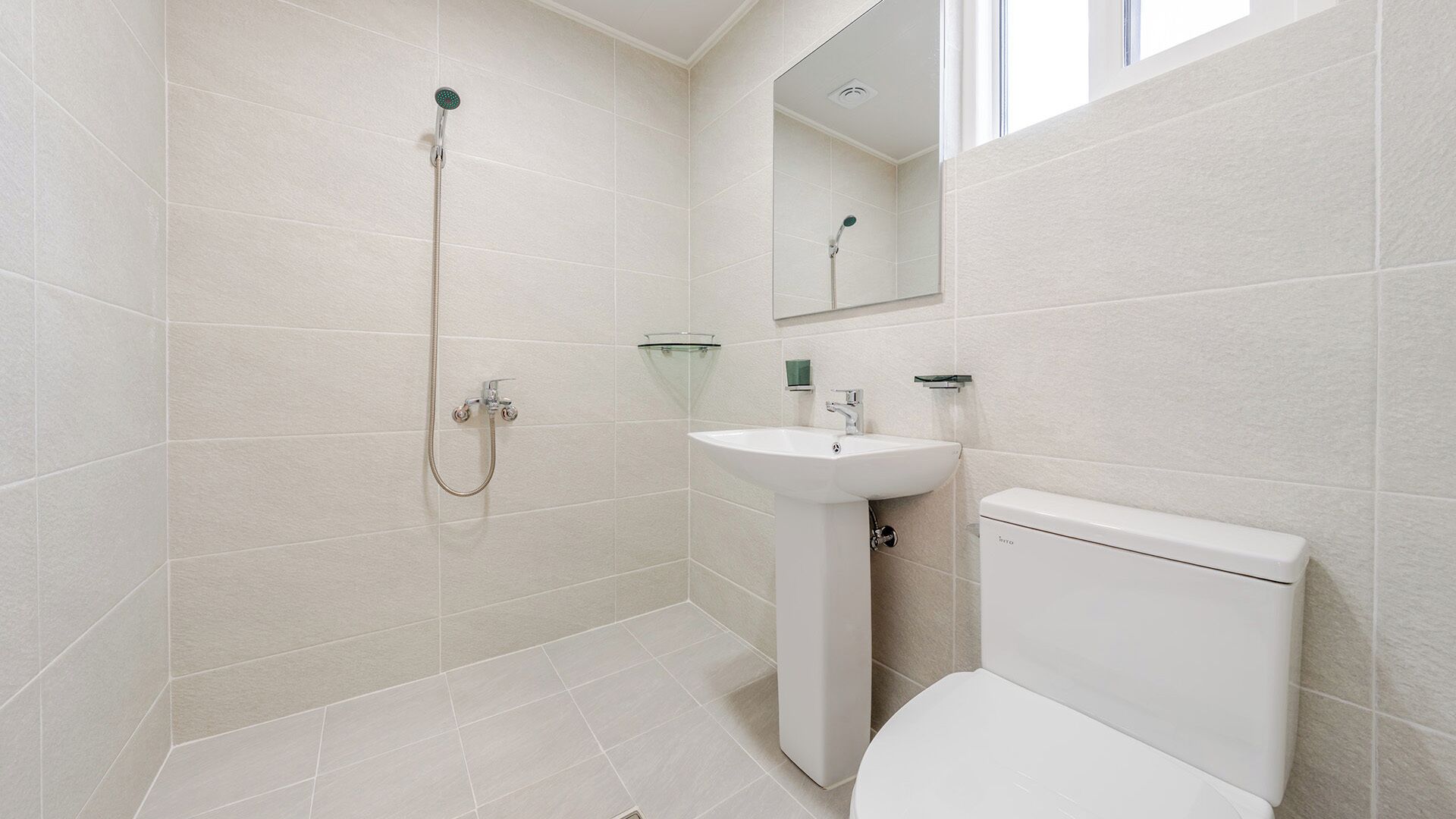 A bathroom with a shower, sink, and toilet.