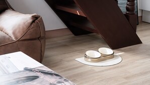 A modern living room with a brown leather sofa, a white coffee table with a magazine, and a pair of bowls on a white tray on the floor. - Ganghwa Aboha Pet-friendly Pension (Incheon)