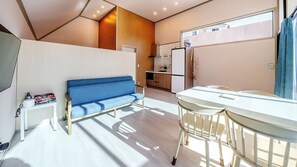 A modern living space with a sofa, dining table, and kitchen area. - Ganghwa Aiem Glamping (Incheon)