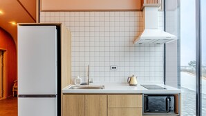 Ett modernt kök med inbyggd mikrovågsugn, kylskåp och diskho.