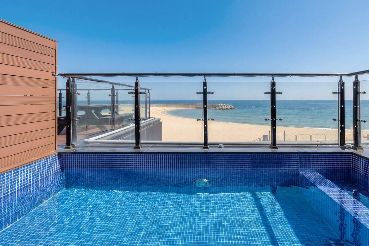 A pool with a view of the beach and ocean.