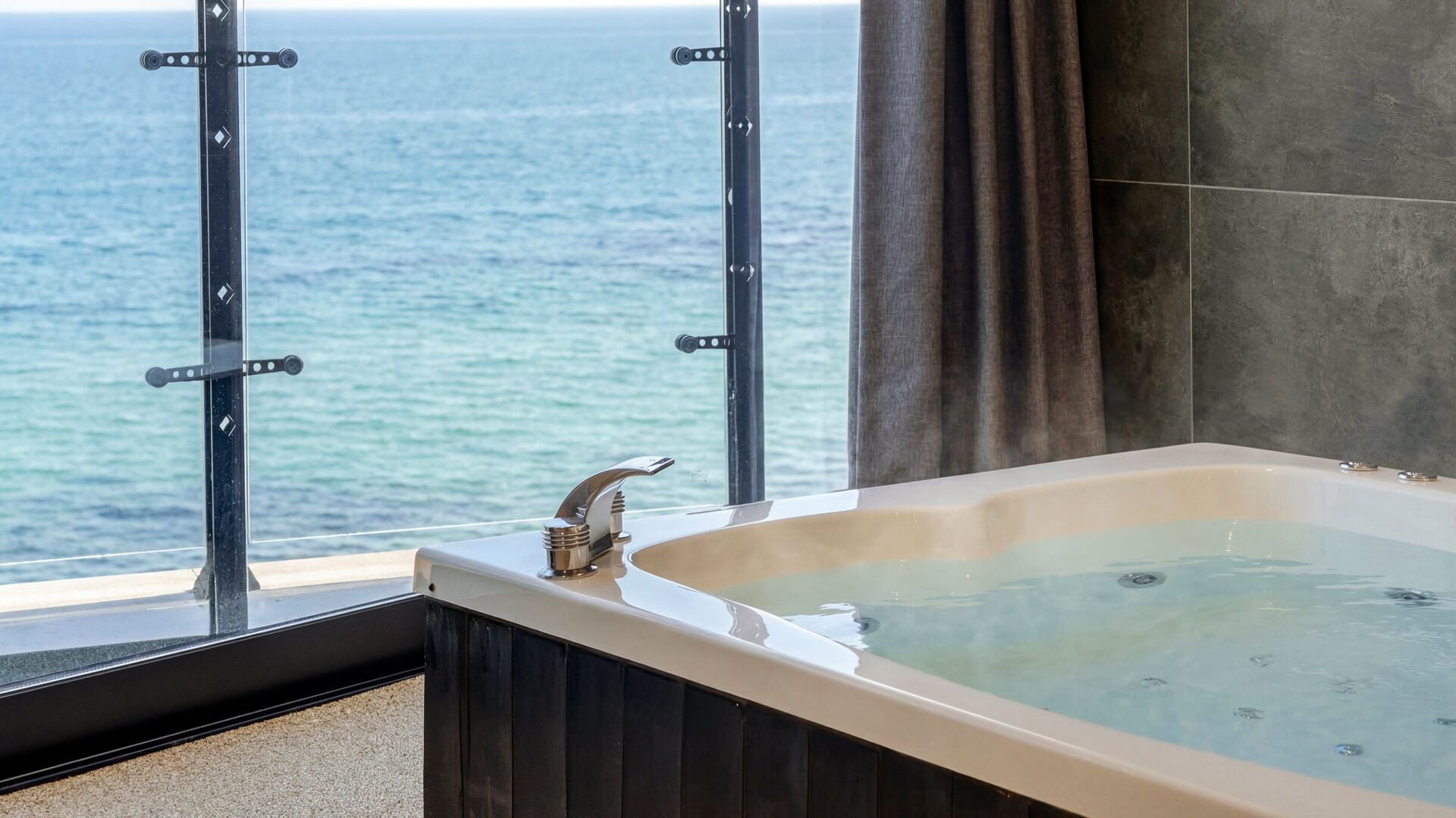 A bathtub with a view of the ocean.
