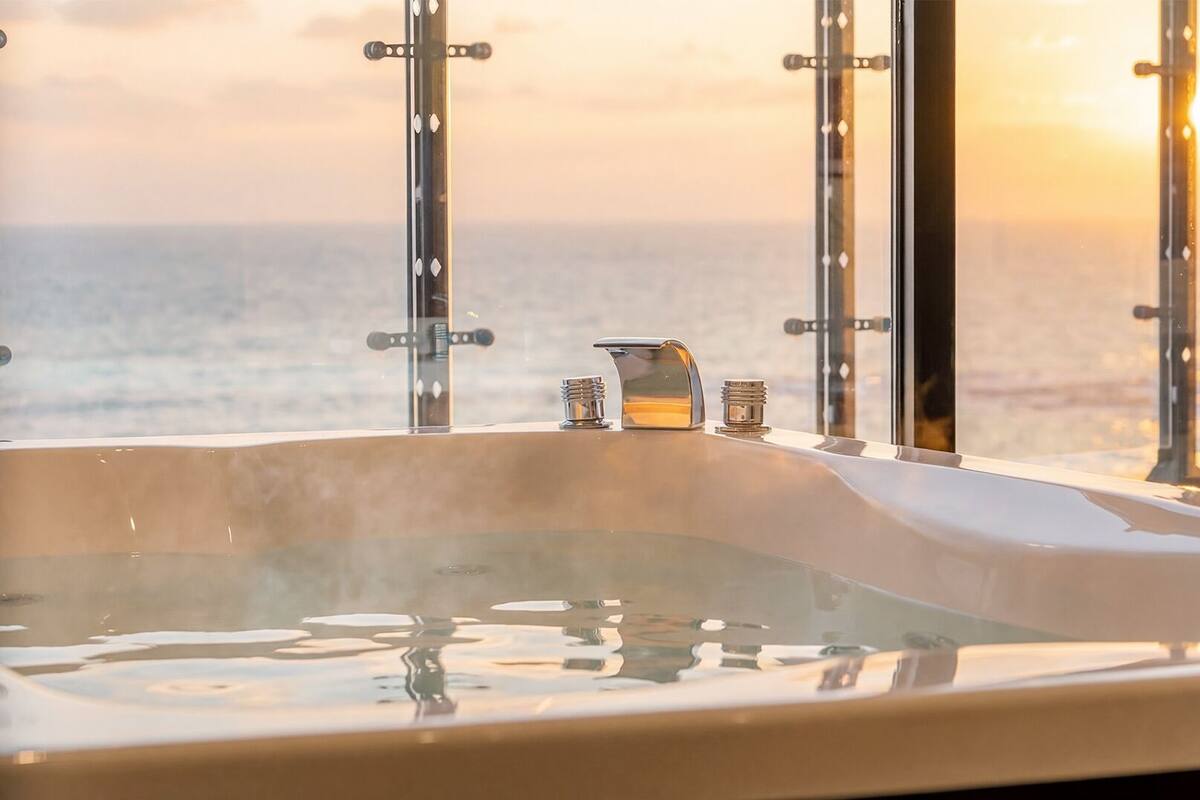 A hot tub with a cityscape view, metal railings, and a small candle.