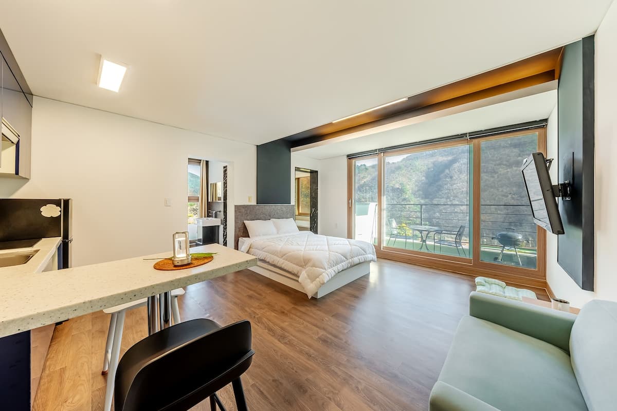 Ein modernes Schlafzimmer mit Bett, Schreibtisch und einer Couch.