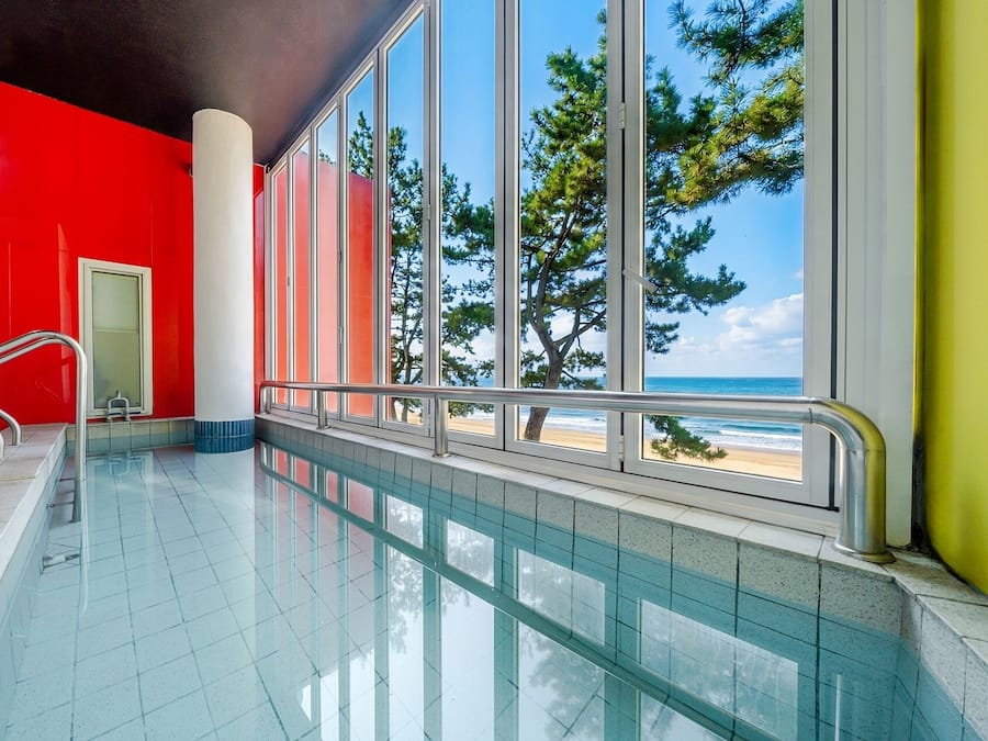A swimming pool with a view of the beach and trees.