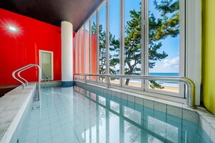 Una piscina con vista a la playa y árboles.