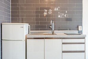 Una cocina moderna con un refrigerador LG blanco, un grifo de acero inoxidable y un salpicadero azulejado con motivos de cocina.