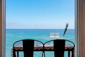 A table with two chairs and two wine glasses, facing a view of the ocean. - Goseong The Wave Pension (Goseong)