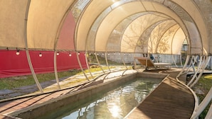 Zona de piscina techada con un deck de madera y una piscina pequeña.