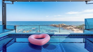 A pool with a heart-shaped float, clear blue water, and a view of the ocean and rocky coastline. - Yeongdeok Searest Poolvilla (Yeongdeok)