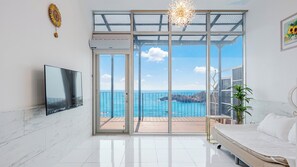 A modern bedroom with a large sliding glass door leading to a balcony with a sea view. - Yeongdeok Searest Poolvilla (Yeongdeok)
