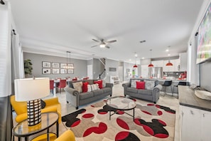 A modern living room with two sofas, a coffee table, and a dining area with chairs. - 4177 Paragraph Drive (Kissimmee)