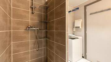 A modern bathroom with a shower, a toilet, and a sink.