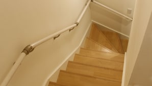 A wooden staircase with white handrails and a light fixture at the top. - Shibuya Honcho household cell (渋谷区)