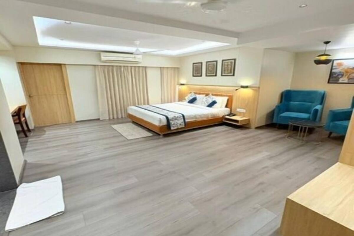 A modern bedroom with a bed, a desk, a chair, and a ceiling fan.