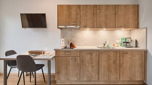 Una cocina moderna con armarios de madera, horno empotrado y cafetera.